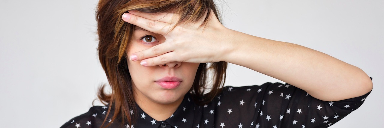 A woman covers her face with her hands