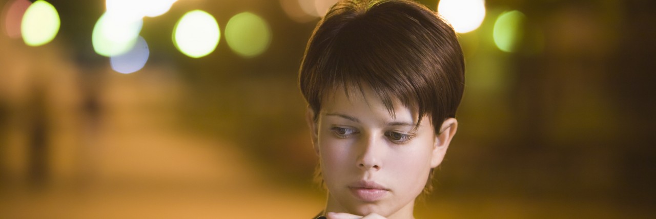 To My Parents, Whose Daughter Struggles With 'High-Functioning' Anxiety Teenage girl stands thinking with mobile phone in street