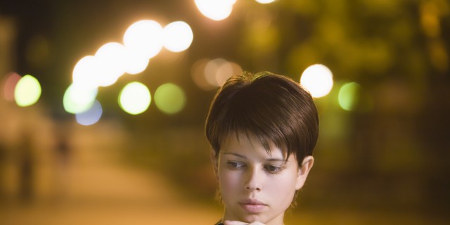 To My Parents, Whose Daughter Struggles With 'High-Functioning' Anxiety Teenage girl stands thinking with mobile phone in street