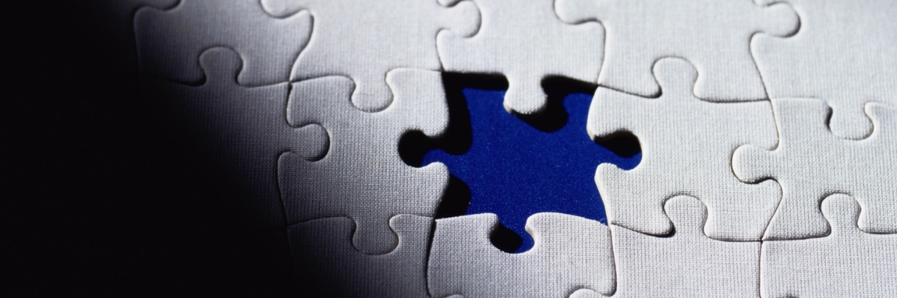 White puzzle pieces, with a blue background, framed by black shadow.