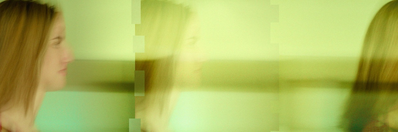 young woman, blurry image of walking through a room.