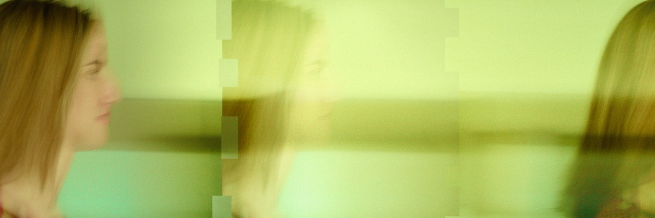 What I Learned From Having Tardive Dyskinesia young woman, blurry image of walking through a room.