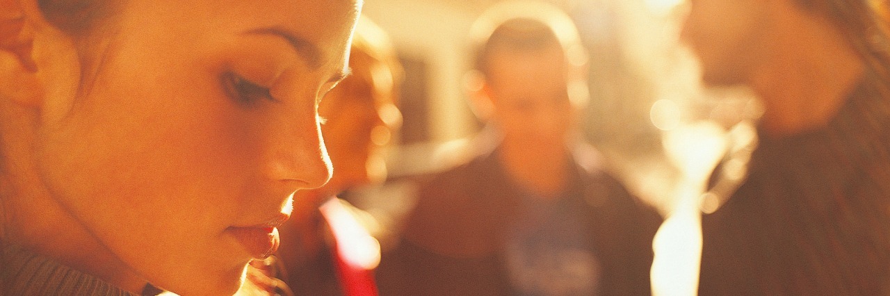 To the Person Who Made a Seizure Joke: You Never Know Who's Listening woman looking sad with group of men in background talking