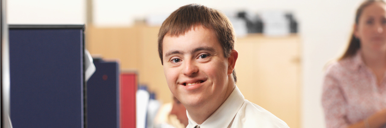 Young man with Down syndrome working in an office.