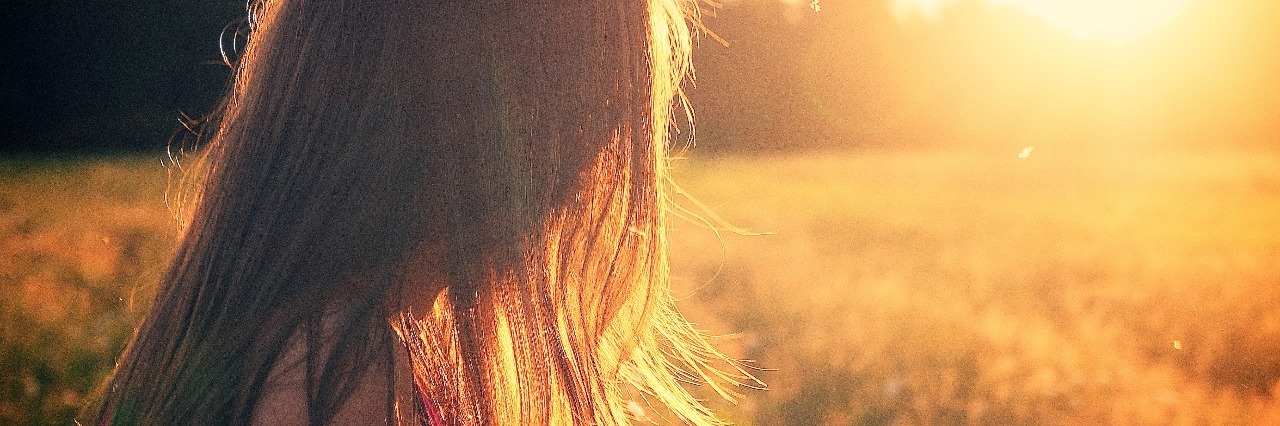 When People Don't Understand the Good Days With Depression woman enjoying sunset in field long hair