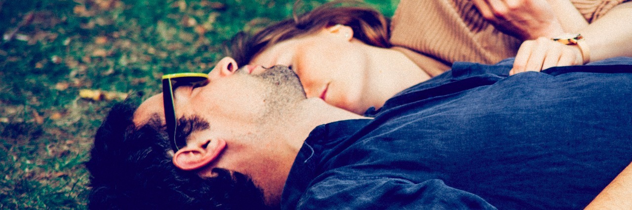 man and woman laying in a field together