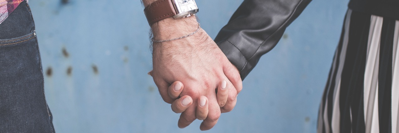 Why I Am Not a Burden, and Neither Are You man with watch and woman leather jacket holding hands couple