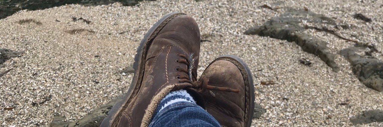 boots on sand overlooking ocean
