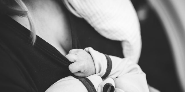 We Need to Talk About Postpartum PTSD baby holding onto mom's shirt