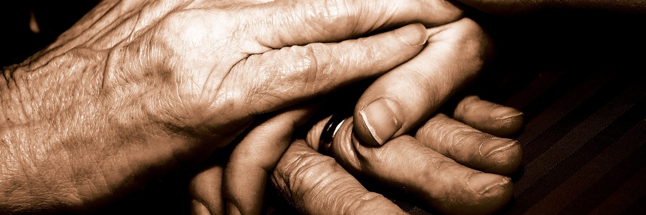 Hands of a grandma holding the hands of a younger person