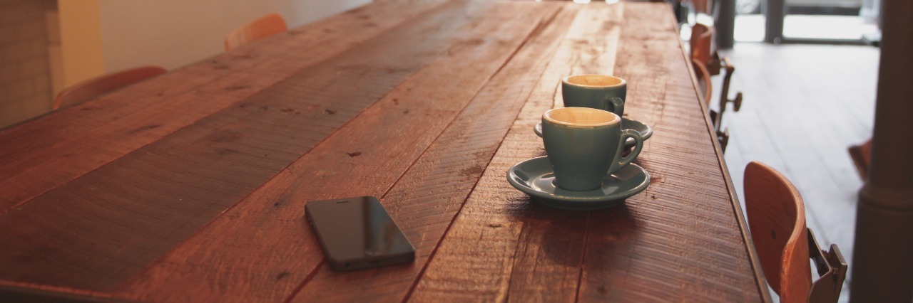 Breaking the Silence and Stigma of Eating Disorders two cups of coffee sitting on coffee shop wooden table beside smartphone