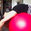 Woman arched over a balance ball at home