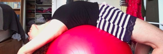 Woman arched over a balance ball at home