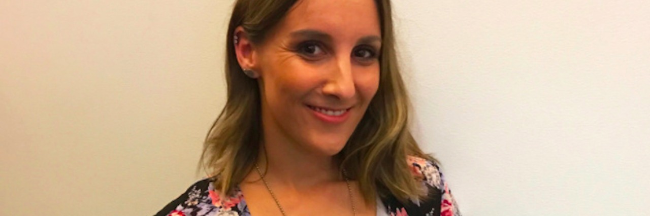 Woman wearing a white top and a floral cardigan