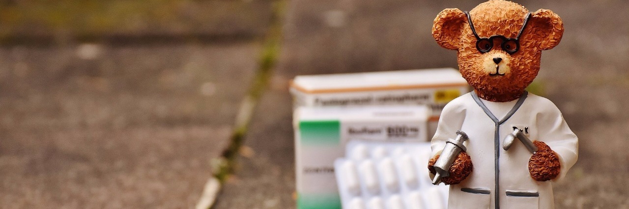 How to Prepare for Your Doctors Appointment A bear figurine on the gourd outside that looks like a doctor, medication behind him.
