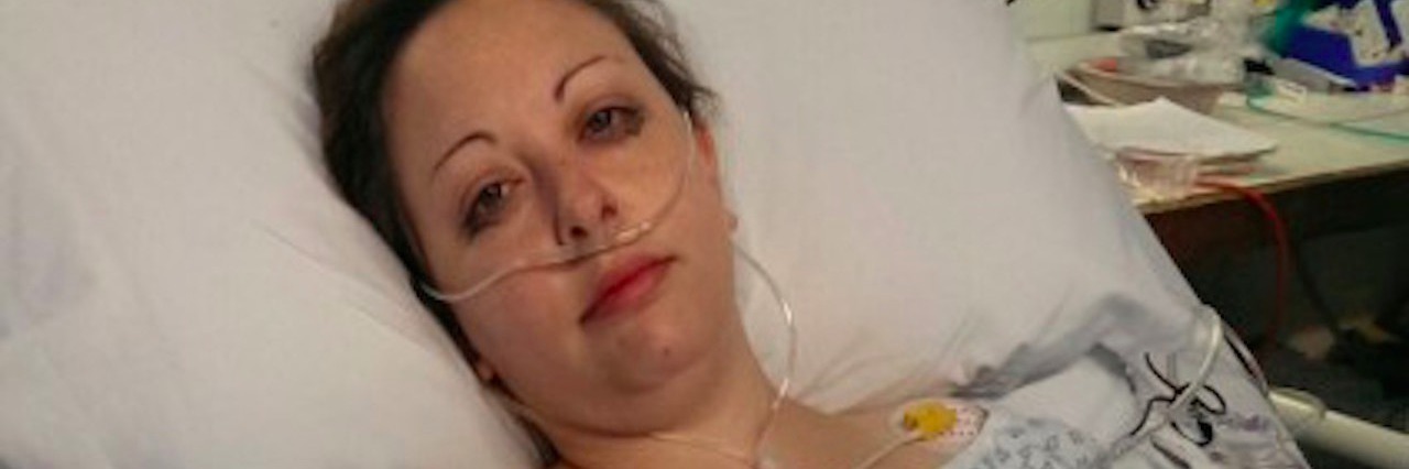 How the Stages of Grief Apply to Chronic Illness and How to Cope woman in hospital bed giving thumbs up