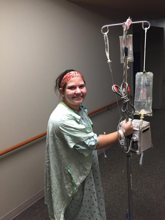girl at hospital standing next to iv pole