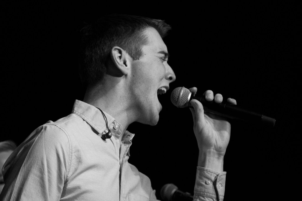 black and white photo of a young man singing
