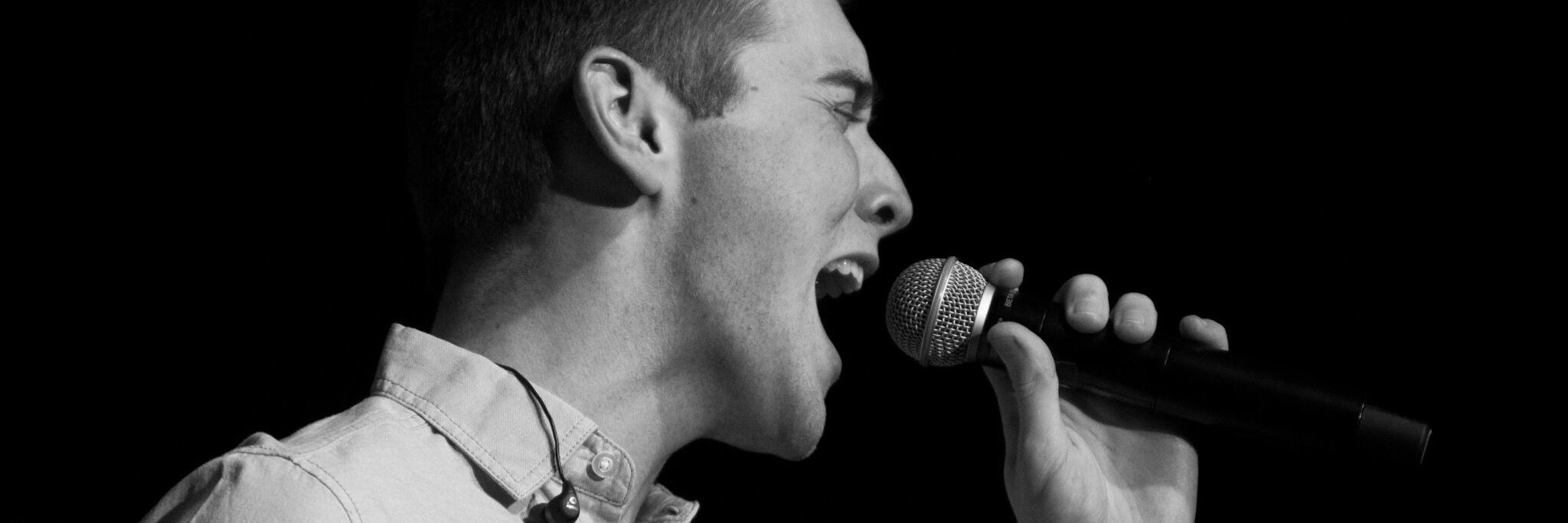 black and white photo of a young man singing
