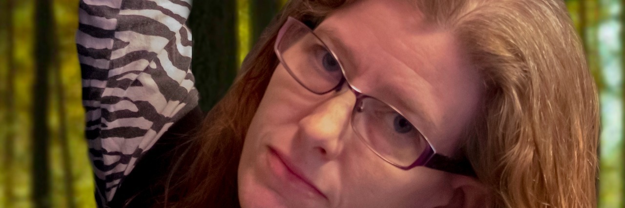 What “Hanging in There” With Ehlers-Danlos Syndrome Really Means girl holding on to tree branch with one hand