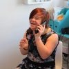 Heidi Crowter, a woman with Down syndrome, sitting ona chair, smiling, and talking on the phone