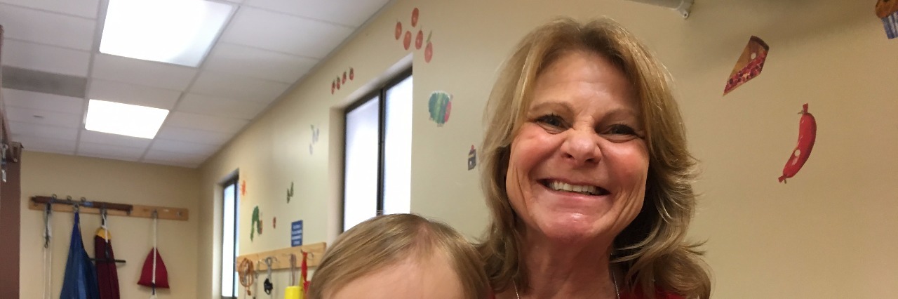 To My Son's Physical Therapist, Thank You and Farewell A little boy with Down syndrome sitting on his therapist's lap for a photo