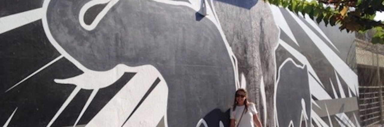 Lessons From Elephants About Supporting Loved Ones Through Illness girl standing next to painting of elephants