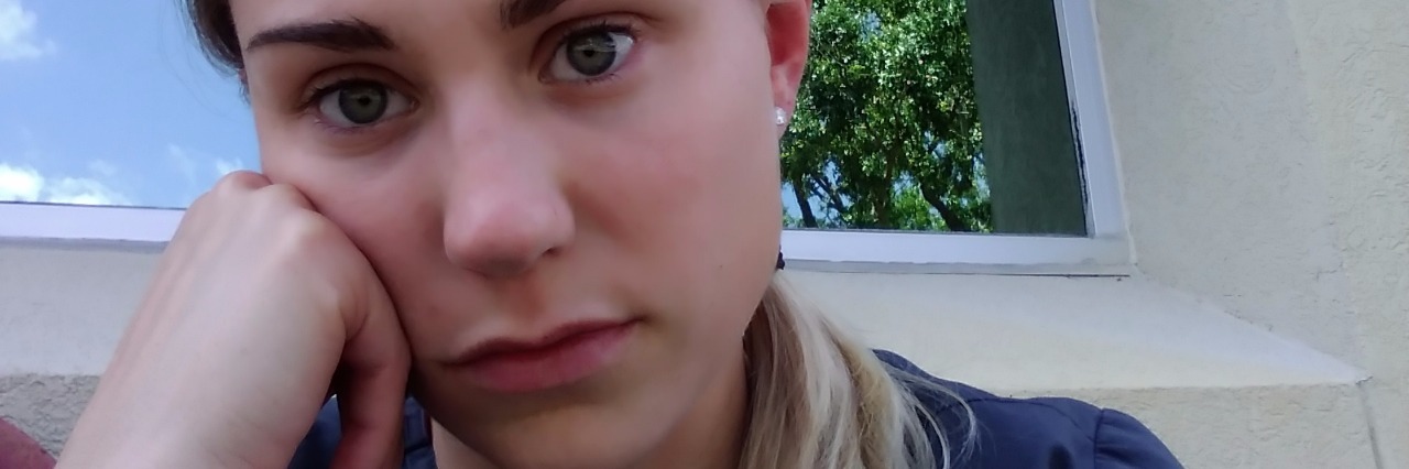 Why Depression Isn't Always What You Think It Is contributor girl with short hair and head on hand looking depressed