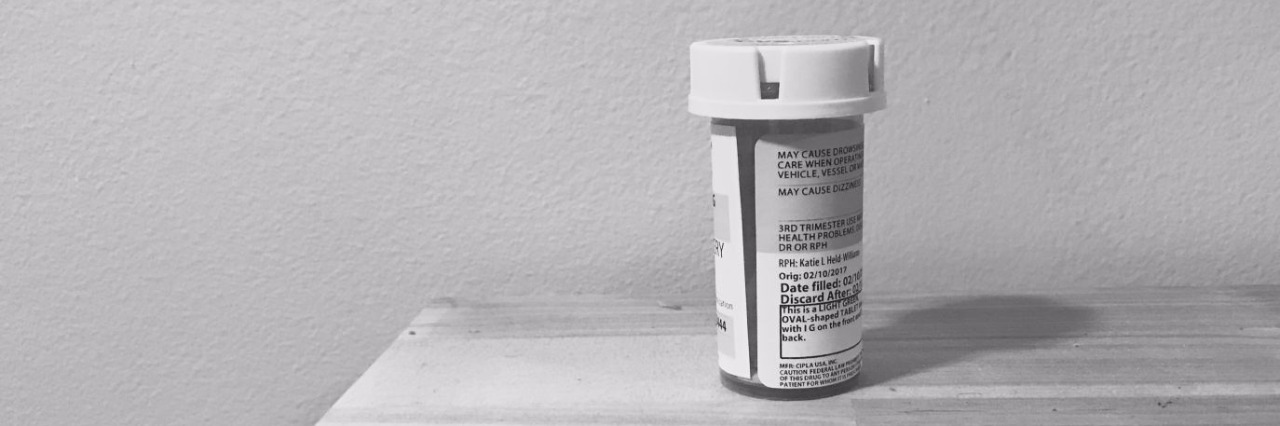 black and white picture of pill bottle on a table