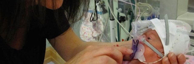 Mom holding premature baby in hospital