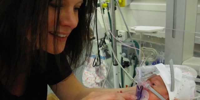 4 Reasons Why I Decided on an 'Academic Redshirt' for My Former Preemie Mom holding premature baby in hospital