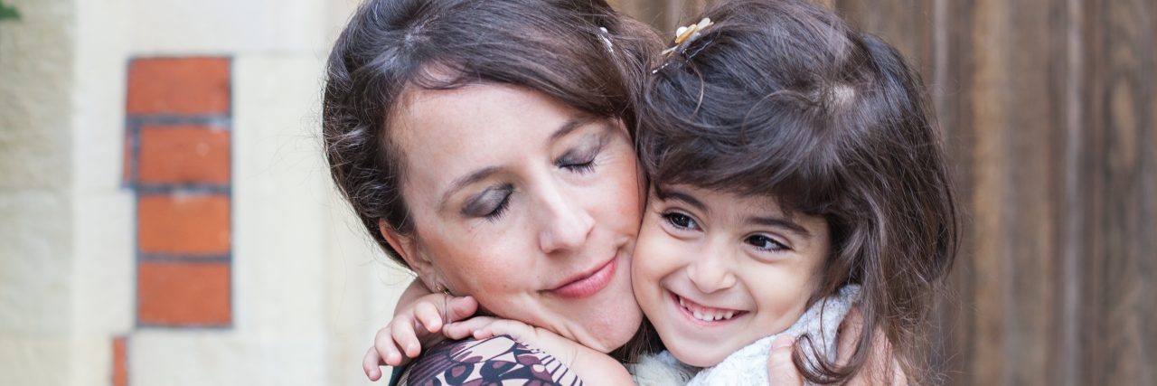 I'm No Saint for Adopting a Child With Disabilities mom holding smiling daughter