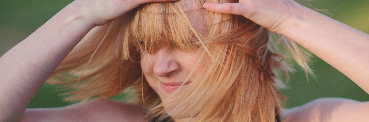 contributor with blonde hair wearing guns n roses band t-shirt with hands in hair