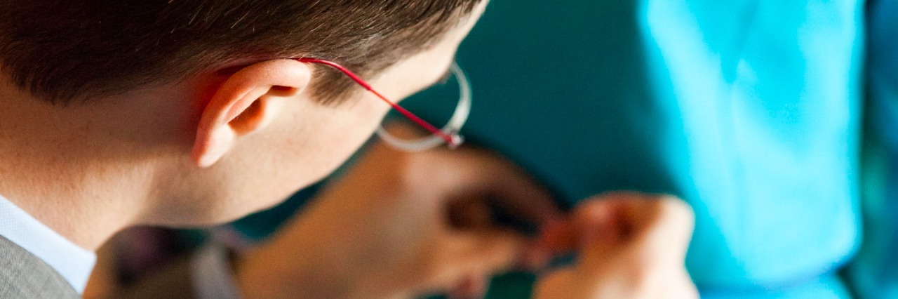 Michael Ryan Andolsek Designer With Autism Creates Women's Apparel Image of a man sewing a dress.