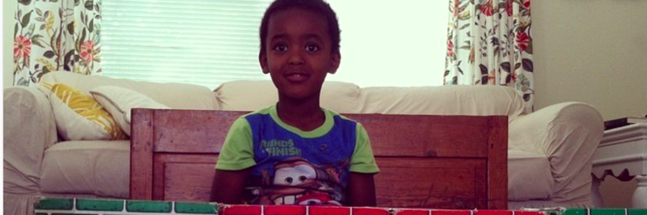 My Lesson for Autism Awareness Month About Redefining Success The author's son in the living room in front of stacked blocks that look like bricks