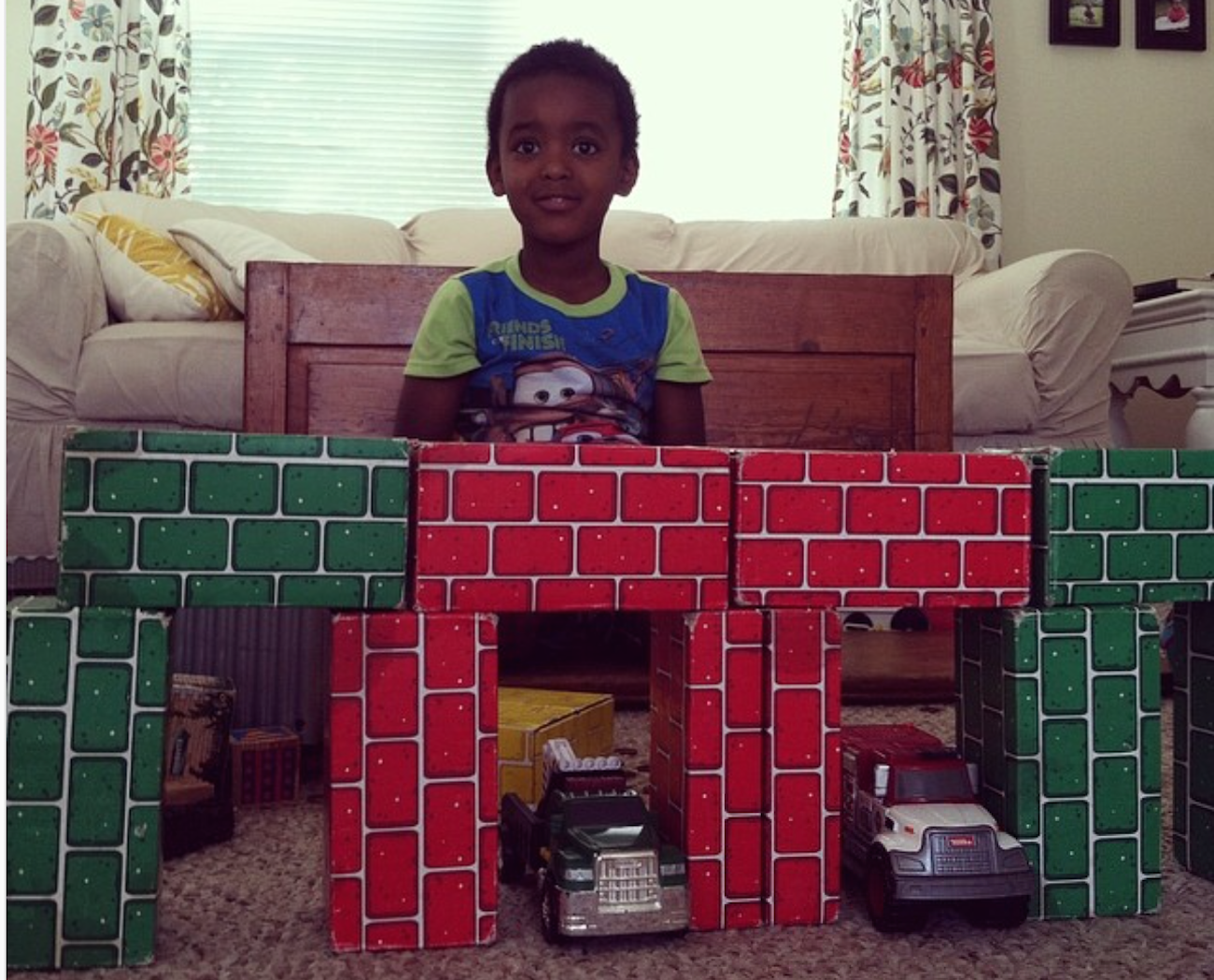 The author's son in the living room in front of stacked blocks that look like bricks
