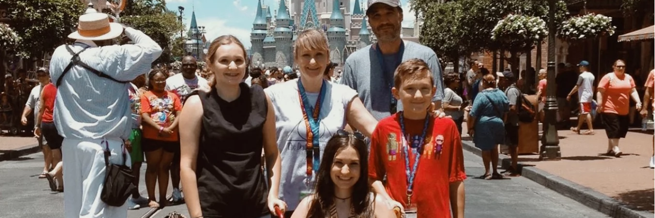 Simple Ways to Help Someone Who Is Chronically Ill family of five posing at disneyland in front of the castle
