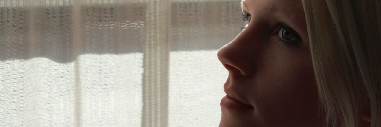 5 Ways Surviving Childhood Sexual Abuse Affects My Everyday Adult Life Young woman standing by window, close-up