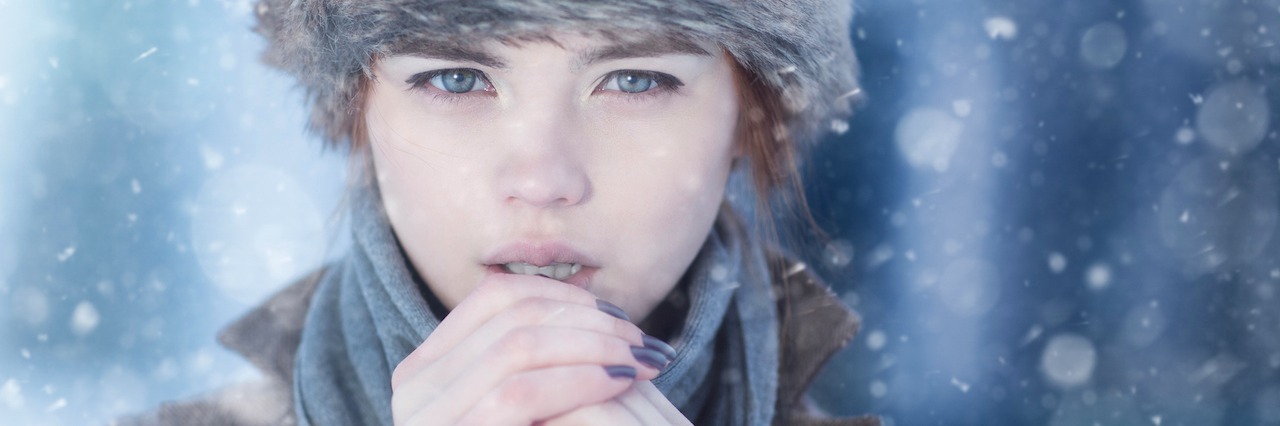 The Vicious Cycle of Chronic Pain and Depression A woman standing in falling snow.