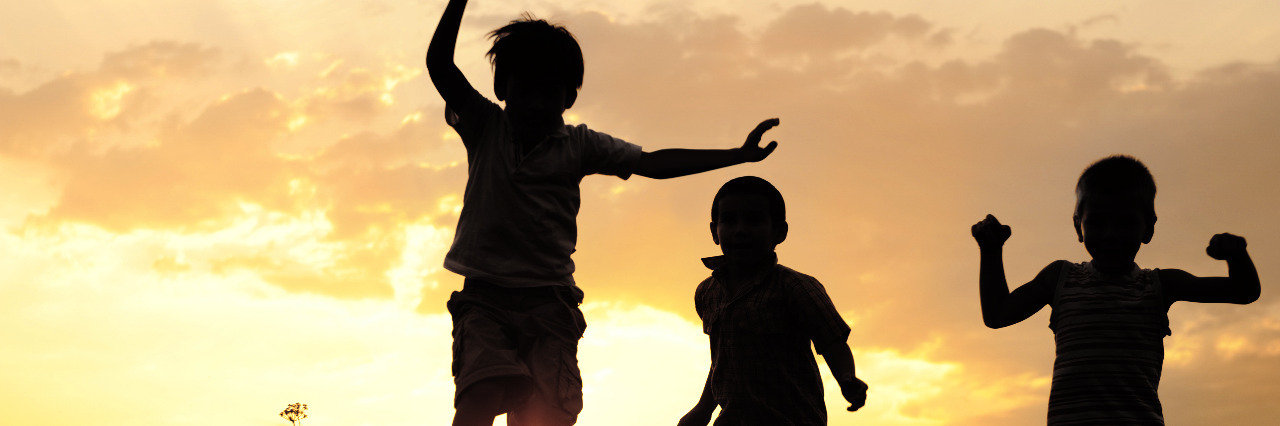 Being a Mother With Cerebral Palsy Children running in meadow at sunset.