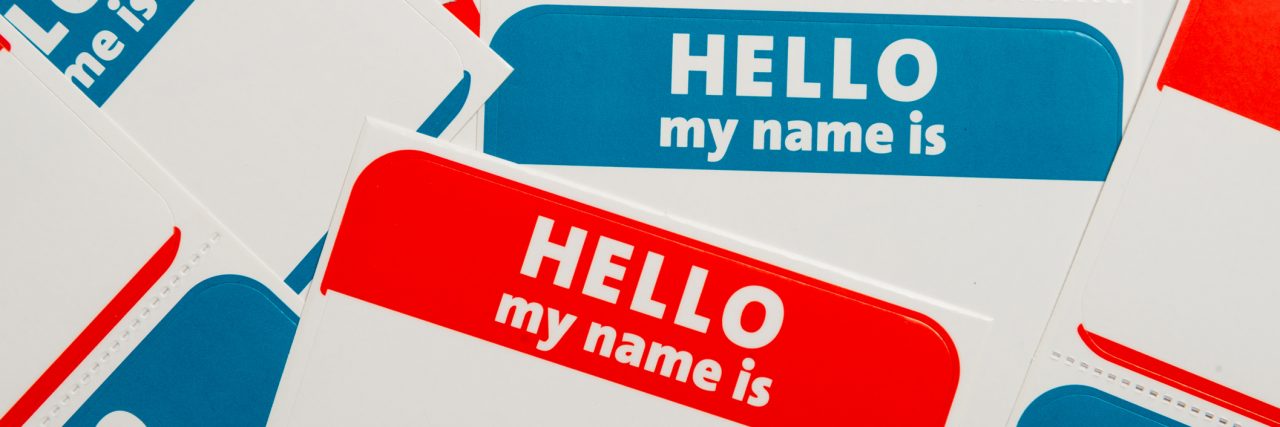 Why Labeling People as Their Mental Illness Can Be Problematic A stack of blue and red "Hello, my name is" name tags or badges