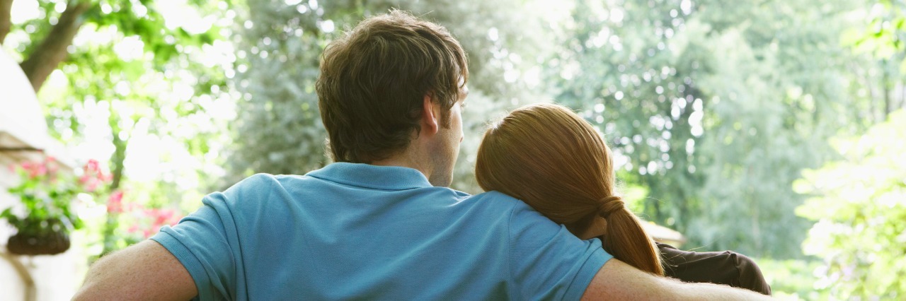 A Thank-You Letter to Caregivers of Those With CRPS Couple on bench, woman resting head on man's shoulder, rear view