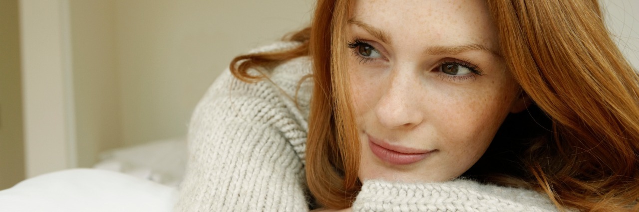 woman with red hair leaning on her arms and smiling