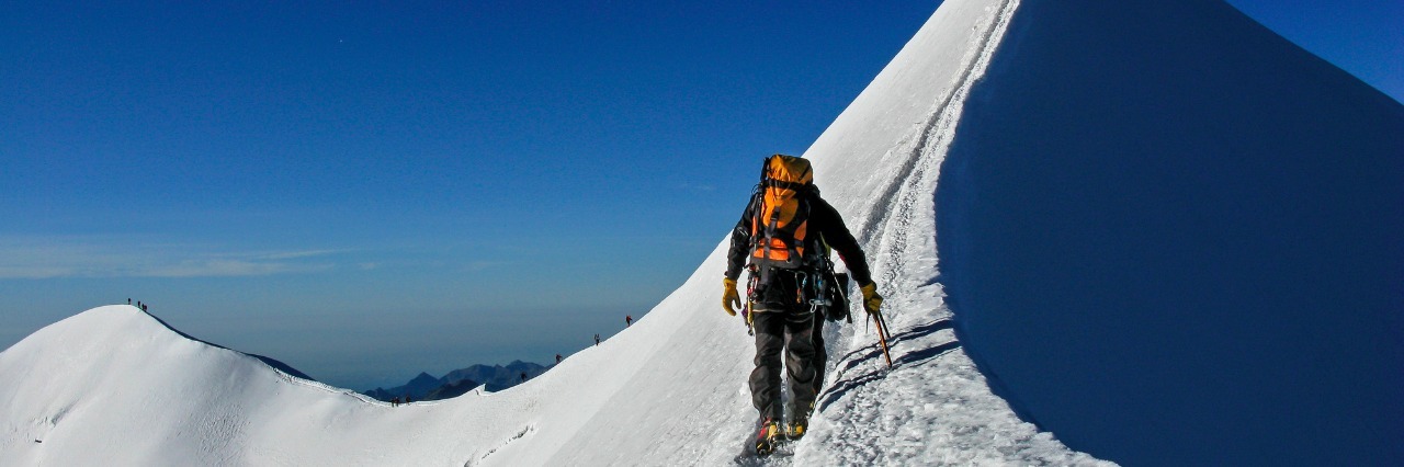 person climbing snowy mountain