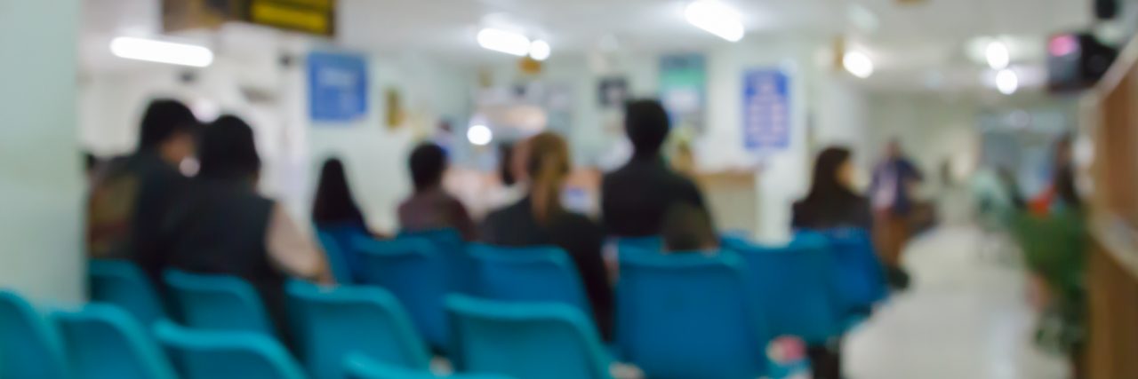 blurry defocused image of patient sitting on chair waiting for doctor in public hospital for background