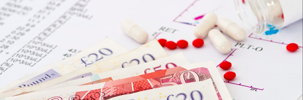 The Costs of Being Chronically Ill in the UK With the NHS Medical report with test results, pills and money. Concept of expensive healthcare
