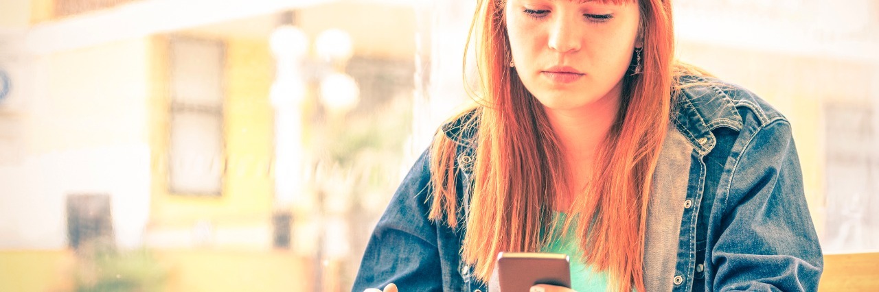 5 Things I'm Tired of Hearing People Say as Someone With Crohn's Disea Vintage filtered portrait of serious pensive young woman with smartphone - Hipster girl using mobile smart phone