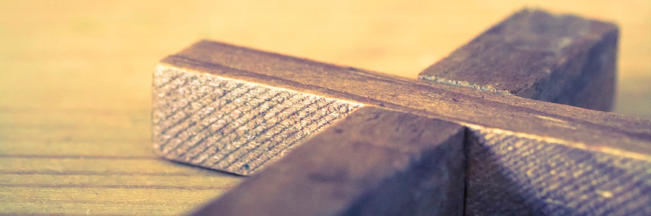Why Religion Was Bad for My Anxiety A wooden Christian cross with a soft lights background.
