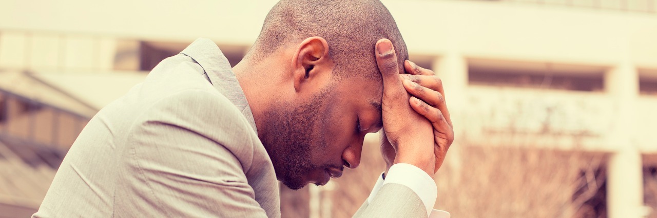 The Importance of Patience With Dysautonomia, POTS man sitting at table with head on hands