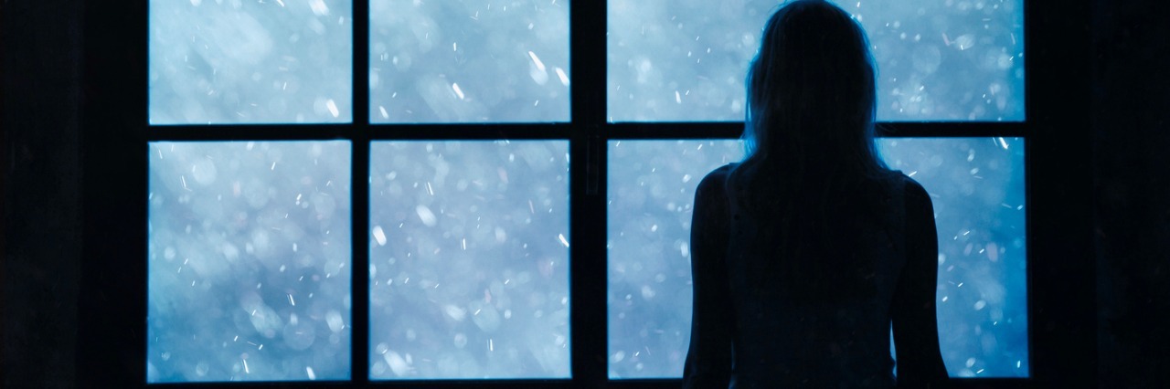 Why I Won't Apologize for Grieving My Fibromyalgia Diagnosis silhouette of woman looking through window at snow
